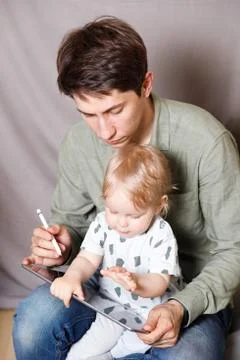 Work from home. This is a developer working on a tablet computer with childre Foto stock