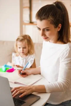 Work at home during quarantine. Mom with a child. Stock Photos
