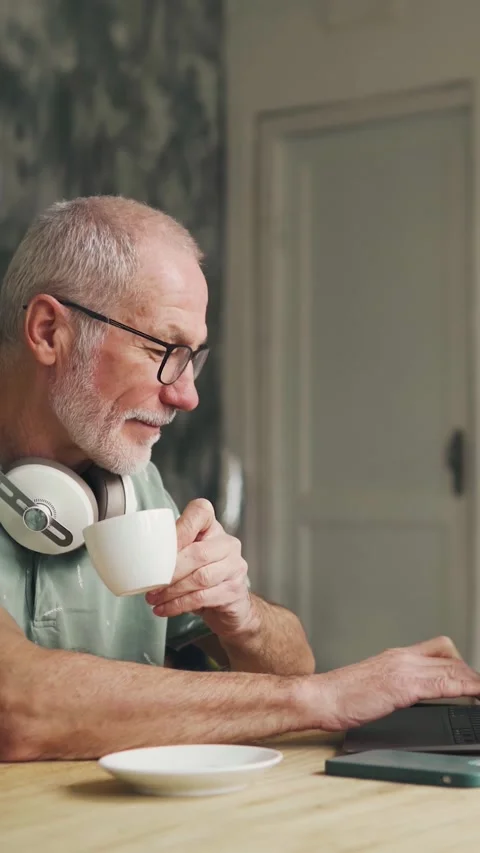 Work from home. An old man in his 60s works on a computer. Elderly pensioner man Video stock 308636235
