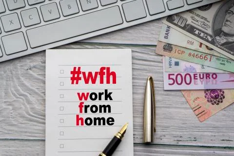 WORK FROM HOME #WFH text with notepad, keyboard, fountain pen 库存照片