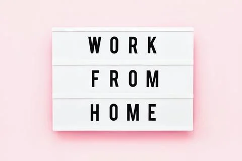 WORK FROM HOME written in light box on pink background. Healthcare and medical Stock-Fotos