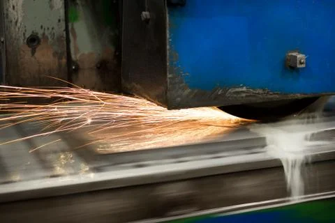 Work of an industrial surface grinding machine. Grinding of a flat metal part. Stock Photos