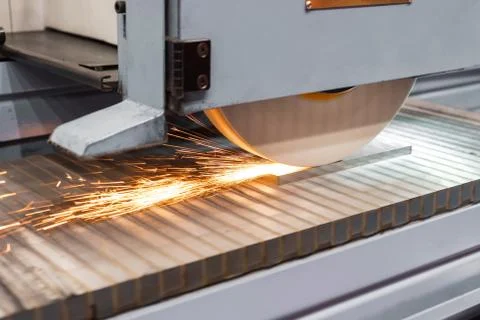 Work of an industrial surface grinding machine. Grinding of a flat metal part. Stock Photos