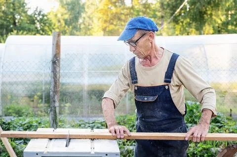 Work on the infield. Do it yourself. A carpenter processes wooden boards on t Stock Photos