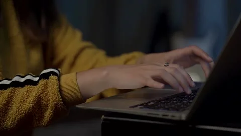 Work on a laptop, a set of text on the keyboard. Women's hands in a yellow Stock Footage 217387597