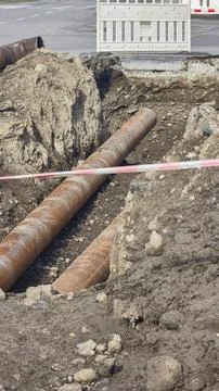 Work on laying utility lines. A large trench and two massive metal pipelines. Fotos de archivo