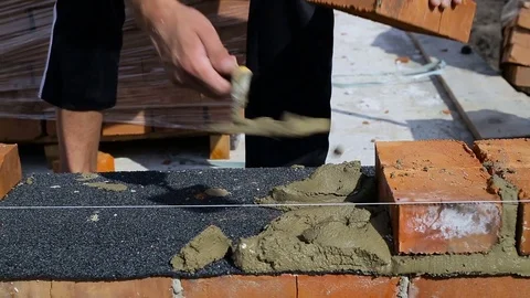 Work lays bricks on a construction site on open air Stock Footage
