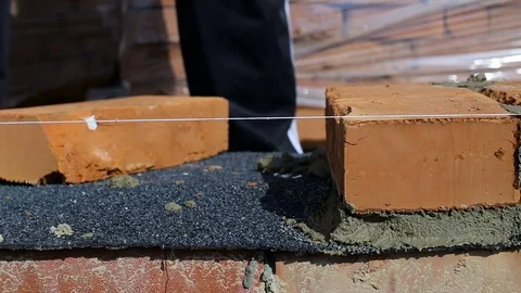 Work lays bricks on a construction site on open air Stock Footage