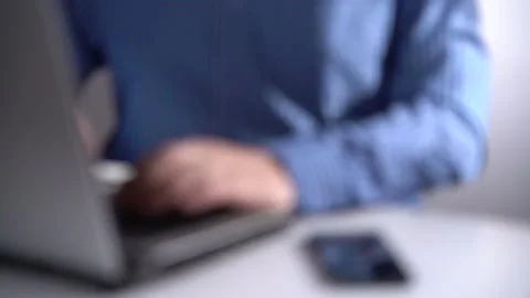 Work in a Light Modern Office. Young Modern Man Working on Laptop. Blurred Video Stock Footage 169091950
