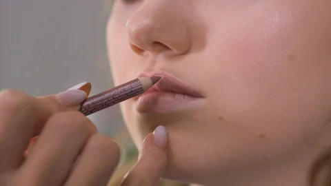 Work of a makeup artist. Stroke the lip contour with a brown correction pencil. Stock Footage 123427019