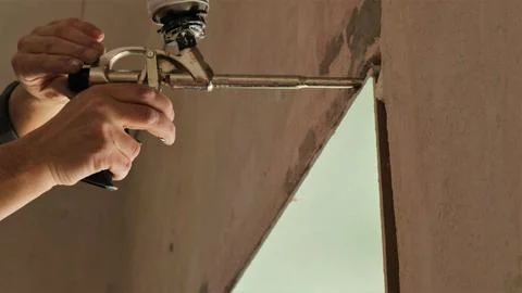 Work with a mounting gun when installing slopes Stock Photos