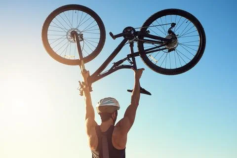 Work out and be proud of your results. Rearview shot of a male cyclist lifting Stock Photos