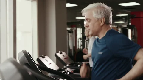 Work out at Gym Room Inside Fitness Center. Healthy Old Man Warming Up on Treadm Stock Footage 199478896