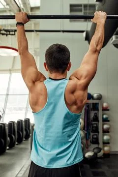 Work with own weight, the athlete does exercises on the uneven bars. Fotos Stock
