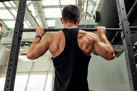 Work with own weight, the athlete does exercises on the uneven bars. Fotos Stock