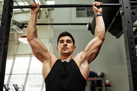 Work with own weight, the athlete does exercises on the uneven bars. Fotos Stock