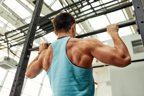 Work with own weight, the athlete does exercises on the uneven bars. Fotos Stock