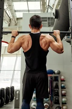 Work with own weight, the athlete does exercises on the uneven bars. Fotos Stock