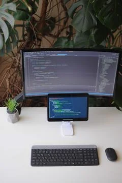 Work place for developer, screen and tablet with code. Comfort working from home Stock Photos