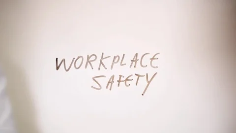 Work place safety written on a clear screen by a safety official Stock Footage 79877796
