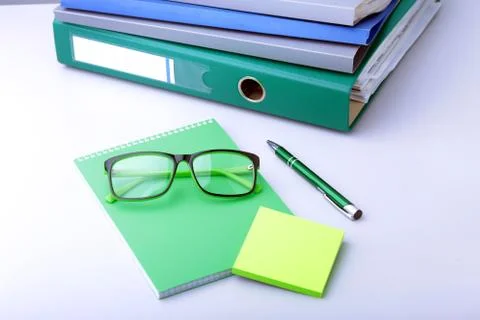 Work place table with folders file on it and modern laptop, pen, glasses and Stock Photos
