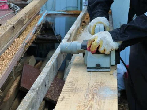 Work with a planer to smooth the texture of the board Stock Photos