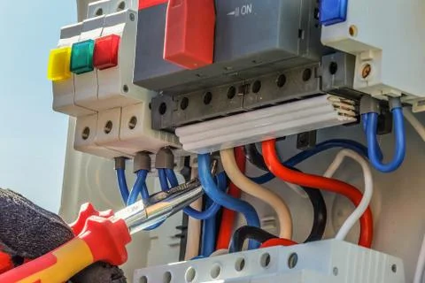 Work pliers in the electrical control panel. Work of the electrician. Stock Photos