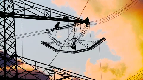 Work on power lines is done during the twilight hours Stock Footage 163085061