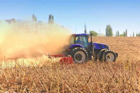 Work of a powerful tractor in field cultivation and cultivation. Agronomy, Stock Photos
