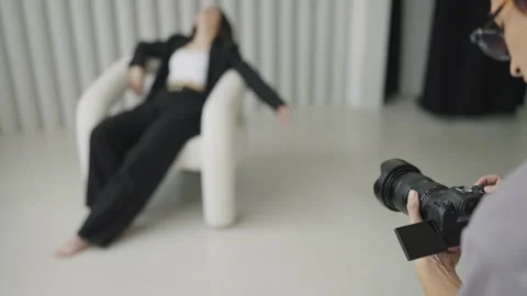 Work professional photographer in studio with model. Young girl posing in Stock Footage 242777108