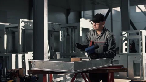 Work of a professional worker with a rivet gun in uniform in the assembly hall Stock Footage 265509267