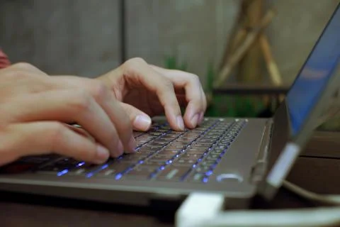 Work in Progress: Close-Up View of Hands Busy Typing on a Laptop Keyboard Stock Photos
