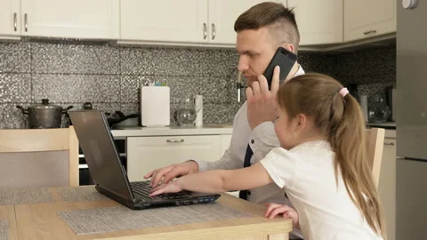Work remotely. Young man works at home. Little daughter wants to play with dad Stock Footage 129615145