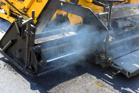 Work on road construction site where asphalt is being laid Stock Photos