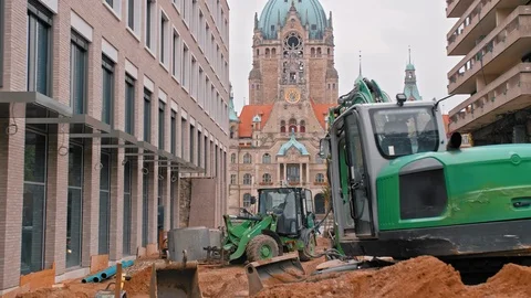 Work on the road. A large green excavator repairs the road next to the town hall Video stock 106467528