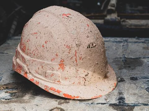 Work Safety Concept. protective construction helmet covered with mud and clay Stock Photos