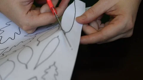 Work with scissors on paper with a printed template on a dark table background Stock Footage 95433491