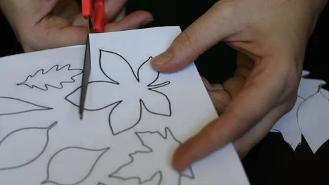 Work with scissors on paper with a printed template on a dark table background Stock Footage 95434159