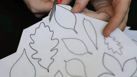 Work with scissors on paper with a printed template on a dark table background Stock Footage 95434210