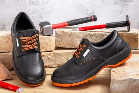Work shoes and tools for doing demolition by hand with old bricks Stock Photos
