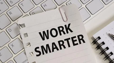 WORK SMARTER text on a paper with notebook and keyboard on a grey background Stock Photos