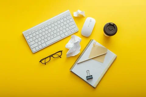 Work space desk layout with note keyboard coffee cup glasses bright color yellow Stock Photos