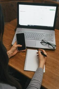 Work space with hands, laptop, notebook, glasses, pen, phone iPhone X Stock Photos