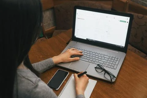 Work space with hands, laptop, notebook, glasses, pen, phone iPhone X Stock Photos