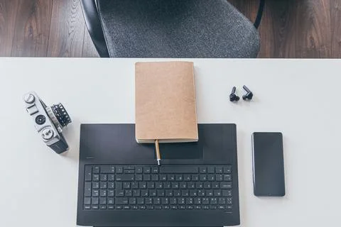 Work space. laptop, notepad, camera, headphones, phone, on white wooden table Stock Photos
