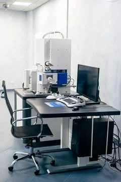 Work space of a scientist with Electron microscope, table and computer Stock Photos