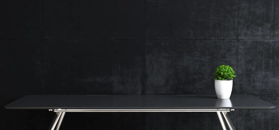Work space stand mock up with table and plant front black concrete wall Stock Photos
