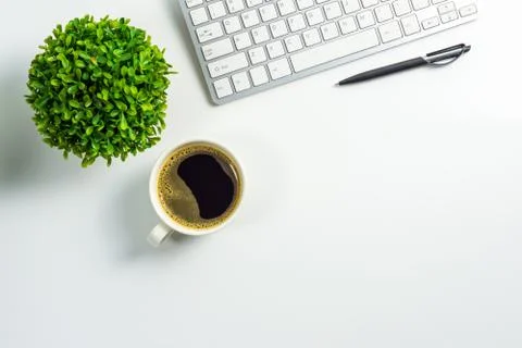 Work space on table with computer keyboard, pen, coffee cup and plant pot, to Foto stock