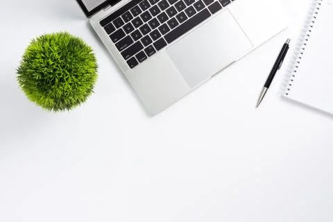 Work space on table with laptop computer, notebook, pen and plant pot, top vi Stock Photos