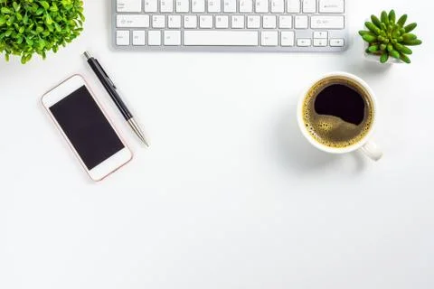 Work space of table with smartphone, pen, coffee cup, computer keyboard and p Stock Photos